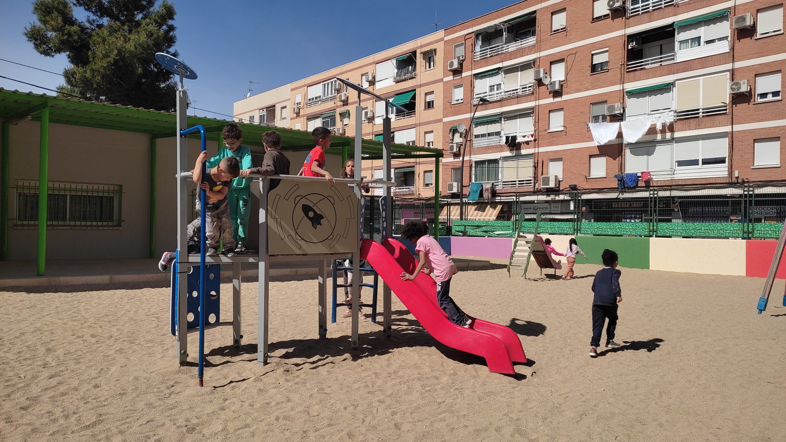 Niños y niñas jugando en un parque de columpios